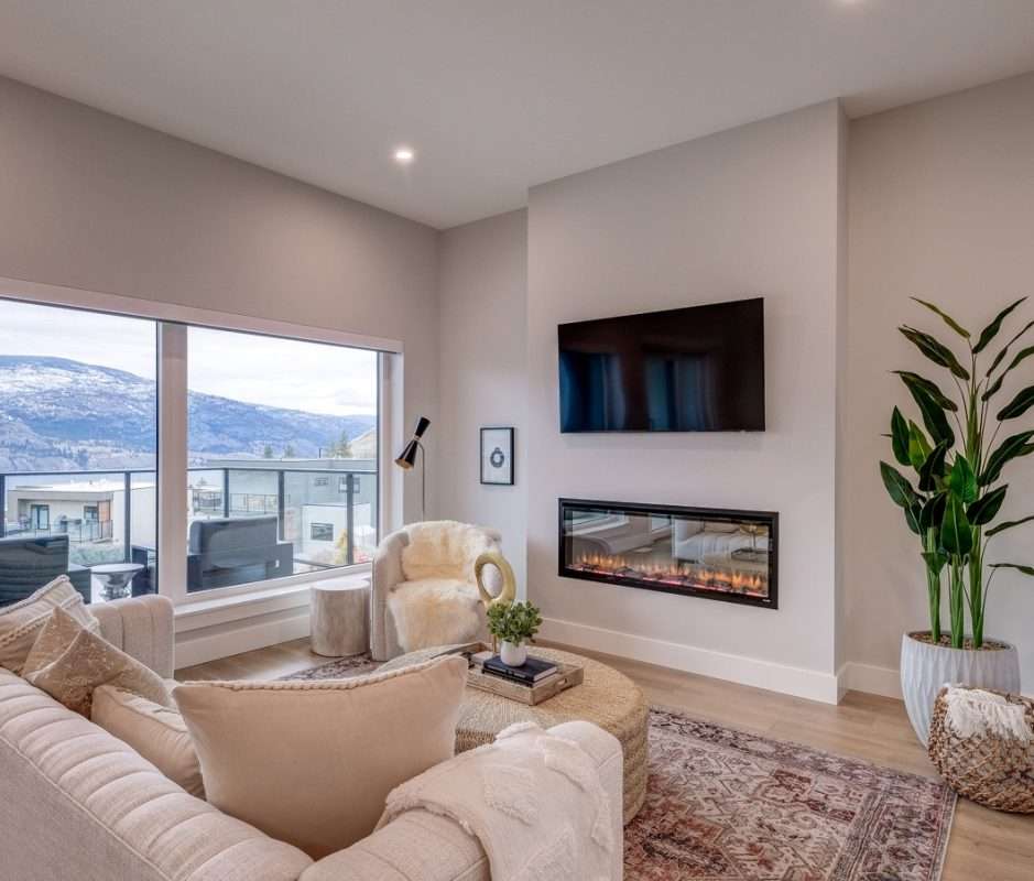 Skaha Hills living room with luxury vinyl plank flooring, fireplace and mountain views