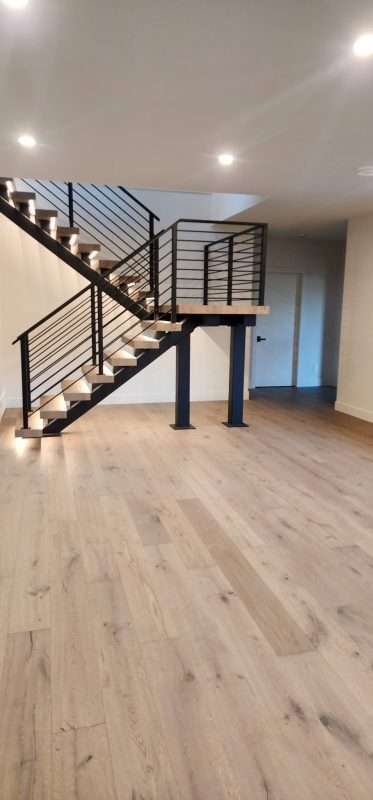 Custom floating hardwood staircase with black steel railing