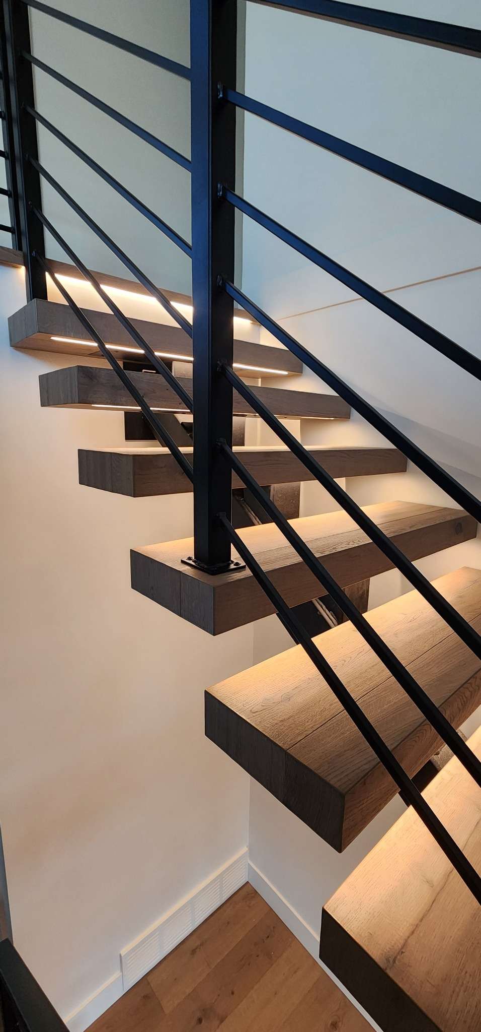 Floating hardwood stair treads with integrated LED lighting
