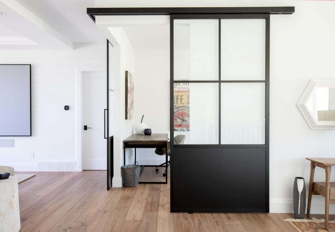 Natural hardwood flooring with black framed sliding door